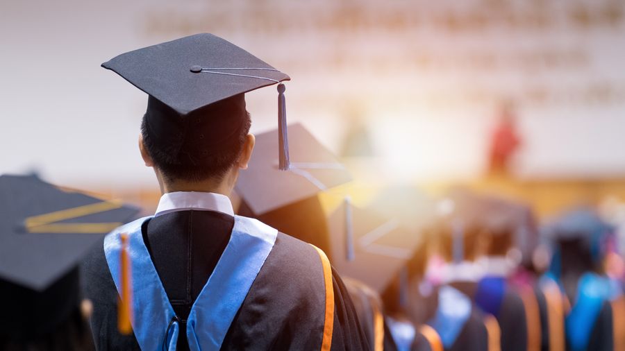 Image of a people graduating with the sun setting on them
